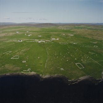 Oblique aerial view centred on the remains of the township, chapel,  burial ground and head-dyke, taken from the WNW.