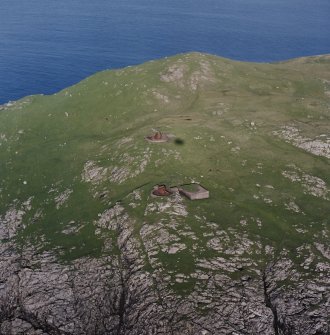 Oblique aerial view centred on the remains of the coast battery, gun emplacements and magazines, taken from the W.