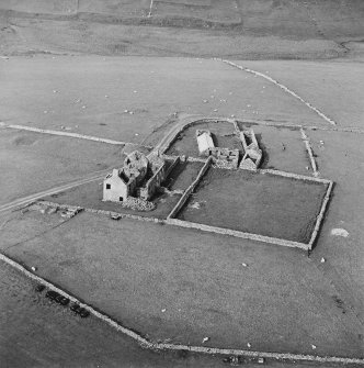 Oblique aerial view centred on the remains of the farmhouse, farmsteading and walled garden, taken from the SW