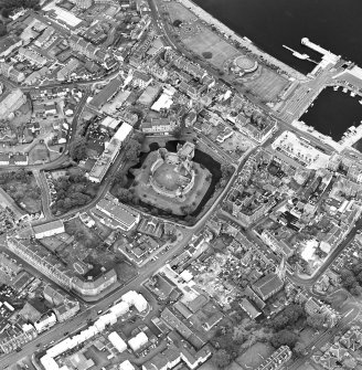 Oblique aerial view of Rothesay, taken from the SE, centred on a castle.  The Winter Gardens is visible in the top centre of the photograph.  The photograph gives a general view of the town.