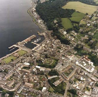 General oblique aerial view of Rothesay centred on the remains of the castle, the harbour and winter gardens, taken from the WSW.