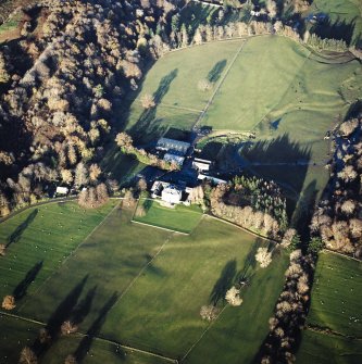 Oblique aerial view centred on the country house, walled garden and farmstead with the remains of the cairn adjacent, taken from the SSW.