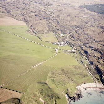 Oblique aerial view centred on the farmhouse, farmsteading, engine house and hut with the remains of the chapel and rig adjacent, taken from the W.