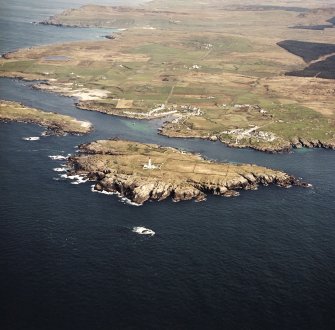 General oblique aerial view centred on the villages, lighthouse, cottage and remains of the chapel and burial ground, taken from the SSW.
