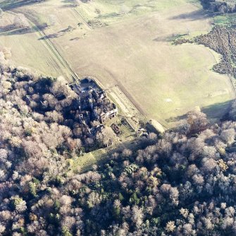 Oblique aerial view centred on the remains of the country house and gardens, taken from the NW.