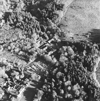 Oblique aerial view centred on the farmstead, the country house and hotel, taken from the W.