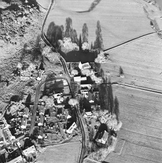 Oblique aerial view centred on the church, churchyard, farmstead and manse, taken from the SW.
