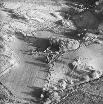 Oblique aerial view centred on the farmhouse, byre, farmsteading and the remains of the earthwork and farmstead, taken from the WNW.