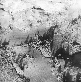 Oblique aerial view centred on the farmhouse, byre, farmsteading and the remains of the earthwork and farmstead, taken from the SW.