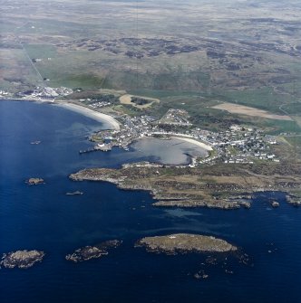 General oblique aerial view centred on the village and harbour with whisky distillery adjacent, taken from the SSE.