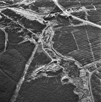 Wilsontown, oblique aerial view, taken from the NE, showing the bings of two coal mines at the bottom, and the remains of ironworks, workers' rows, lime kilns, coke ovens and buildings across the remainder of the photograph, including a large area of bell pits in the centre and top left-hand corner.