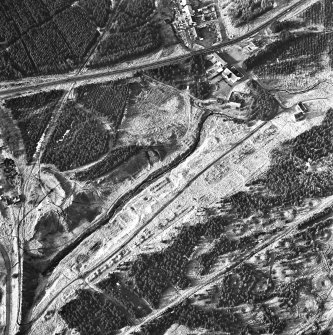 Wilsontown, oblique aerial view, taken from the SE, showing the the remains of ironworks, workers' rows, lime kilns, coke ovens, bell pits, and buildings across the photograph