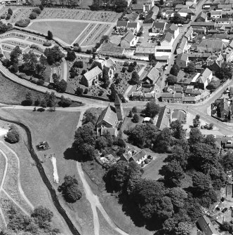 Oblique aerial view of Biggar centred on Biggar Church, churchyard and Moat Park Church, taken from the WSW.