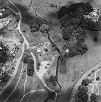 Oblique aerial view centred on the museum and watermill with manse, farmsteading, footbridge and ford adjacent, taken from the SSE.