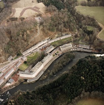 Oblique aerial view of New Lanark centred on the mills and schools, taken from the WSW.
