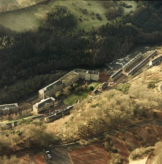Oblique aerial view of New Lanark centred on the school and mills, taken from the ENE.