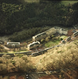 Oblique aerial view of New Lanark centred on the school and mills, taken from the ENE.