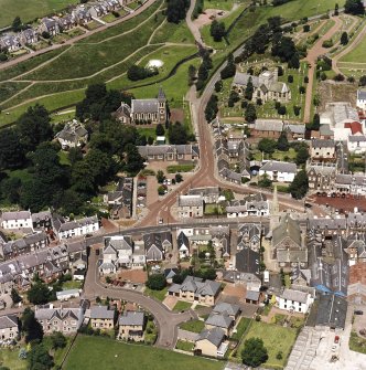 Oblique aerial view of Biggar centred on Biggar Church, churchyard, Moat Park Church and church hall, taken from the SSE.
