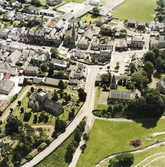 Oblique aerial view of Biggar centred on Biggar Church, churchyard, Moat Park Church and church hall, taken from the NNW.