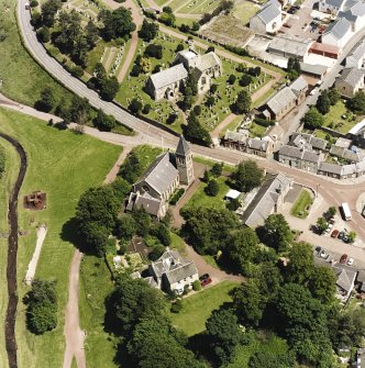 Oblique aerial view of Biggar centred on Biggar Church, churchyard and Moat Park Church, taken from the SW.