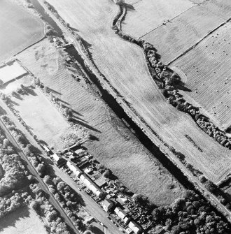 Oblique aerial view of Castlecary centred on the Forth and Clyde canal and lock 18, taken from the ESE.