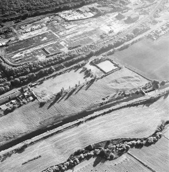 Oblique aerial view of Castlecary centred on the Forth and Clyde canal and lock 18, taken from the NNE.