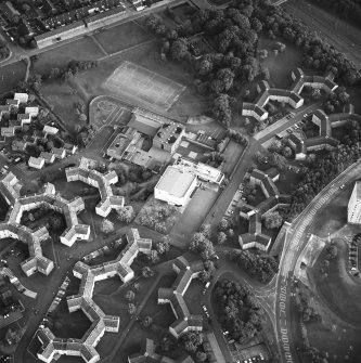 Oblique aerial view of Cumbernauld centred on sacred Heart Roman Catholic Church with the Sacred Heart Roman Catholic Primary School adjacent, taken from the N and recorded as part of the World of Worship project.