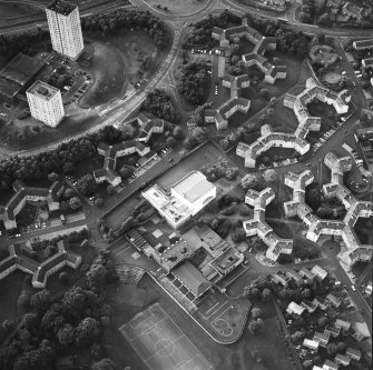 Oblique aerial view of Cumbernauld centred on sacred Heart Roman Catholic Church with the Sacred Heart Roman Catholic Primary School adjacent, taken from the SE and recorded as part of the World of Worship project.