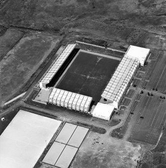 Oblique aerial view centred on the football stadium, taken from the SSE.