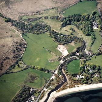 Oblique aerial view centred on the village, burial-ground church and rig, taken from the ESE.