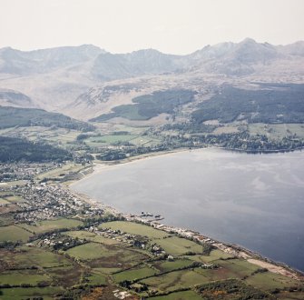 General oblique aerial view looking across the pier, town and Brodick Bay towards Brodick Castle and Goatfell beyond, taken from the SE.