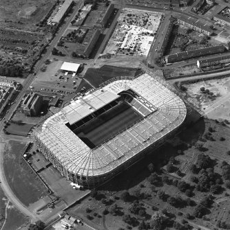 Oblique aerial view, taken from the ENE.
Centred on Celtic Park football stadium, and showing the Eastern Necropolis graveyard in the bottom right-hand corner of the photograph.