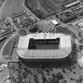 Oblique aerial view, taken from the NE.
Centred on Celtic Park football stadium, and showing the Eastern Necropolis graveyard at the bottom of the photograph.