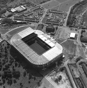 Oblique aerial view, taken from the N.
Centred on Celtic Park football stadium, and showing the Eastern Necropolis graveyard in the bottom left-hand corner of the photograph.