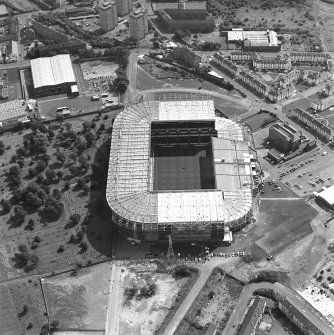 Oblique aerial view, taken from the NE.
Centred on Celtic Park football stadium, and showing the Eastern Necropolis graveyard in the centre left of the photograph.