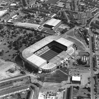 Oblique aerial view, taken from the W.
Centred on Celtic Park football stadium, and showing the Eastern Necropolis graveyard in the centre left of the photograph.