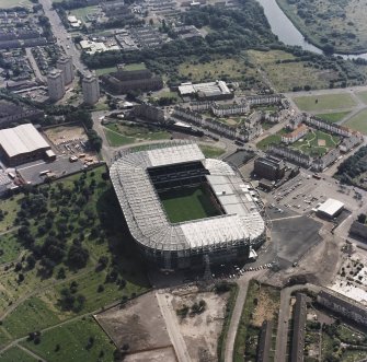 Oblique aerial view, taken from the NW.
Centred on Celtic Park football stadium, and showing the Eastern Necropolis graveyard in the bottom left-hand corner of the photograph.