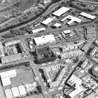 Oblique aerial view centred on Saint Columba's Roman Catholic Church. The Forth and Clyde canal is visible in the top left-hand corner of the photograph.