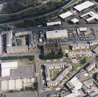 Oblique aerial view centred on Saint Columba's Roman Catholic Church. The Forth and Clyde canal is visible in the top left-hand corner of the photograph.