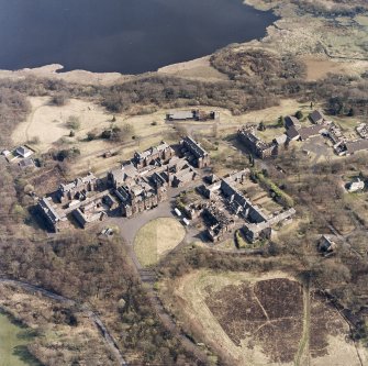 Oblique aerial view centred on the hospital, halls, nurses home, former mortuary, and workshops, taken from the NNW.