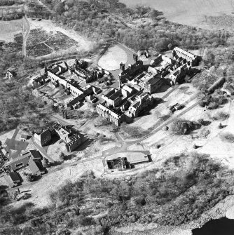 Oblique aerial view centred on the hospital, halls, nurses home, former mortuary, and workshops, taken from the SSE.