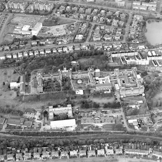 Oblique aerial view centred on the hospital, college and adjoining workshop, taken from the SSW.