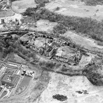 Oblique aerial view centred on the hospital partly under demolition, taken from the NNE.