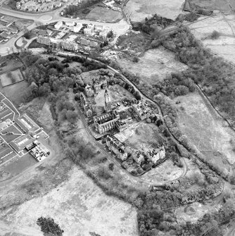 Oblique aerial view centred on the hospital partly under demolition, taken from the NNW.
