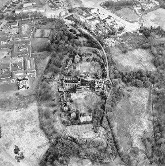 Oblique aerial view centred on the hospital partly under demolition, taken from the NW.