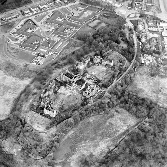 Oblique aerial view centred on the hospital partly under demolition, taken from the WNW.