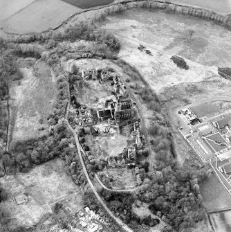 Oblique aerial view centred on the hospital partly under demolition, taken from the SE.