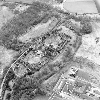 Oblique aerial view centred on the hospital partly under demolition, taken from the ENE.