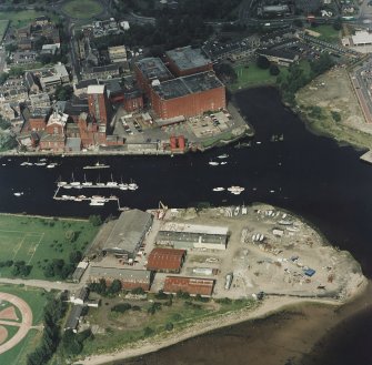 Oblique aerial view centred on the shipyard and whisky distillery, taken from the SSW.
