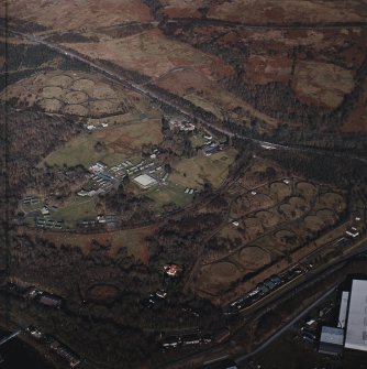 Oblique aerial view centred on the military training camp and farmsteading with oil fuel depots and building adjacent, taken from the SSW.
